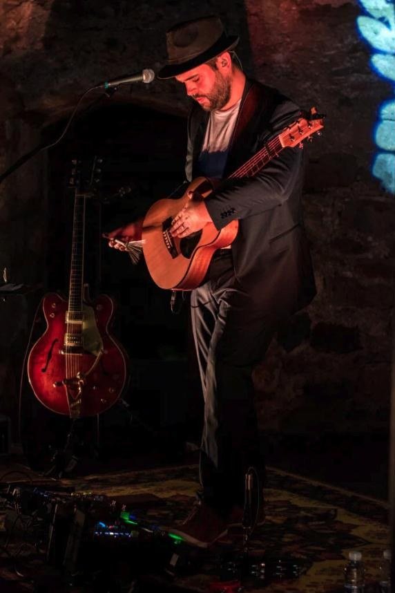 Ander Zubillaga golpeando la caja de la guitarra acústica como percusión